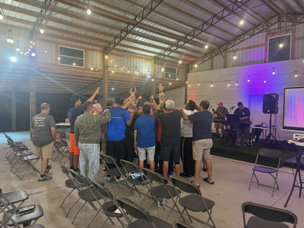 Group of men in prayer circle in pavilion